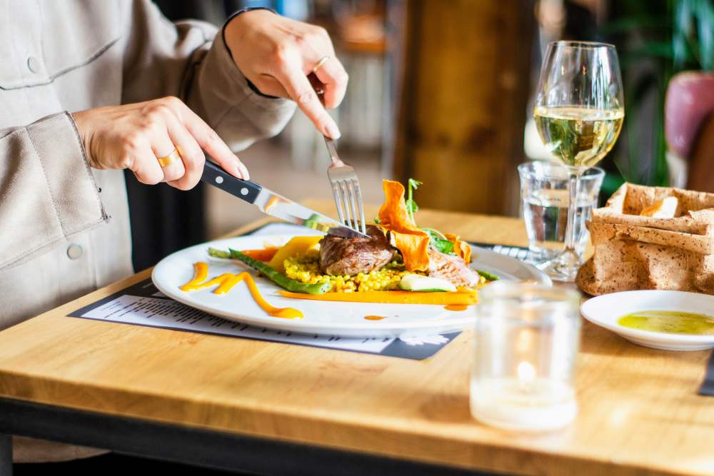 A man using cutlery to eat a meal