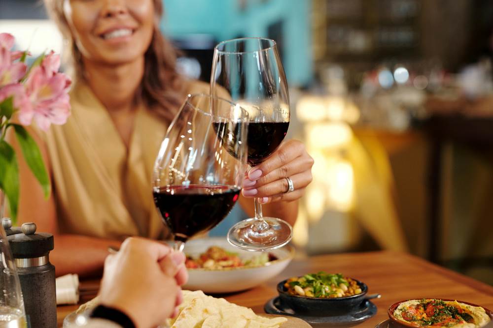 A woman enjoying food and wine with a man