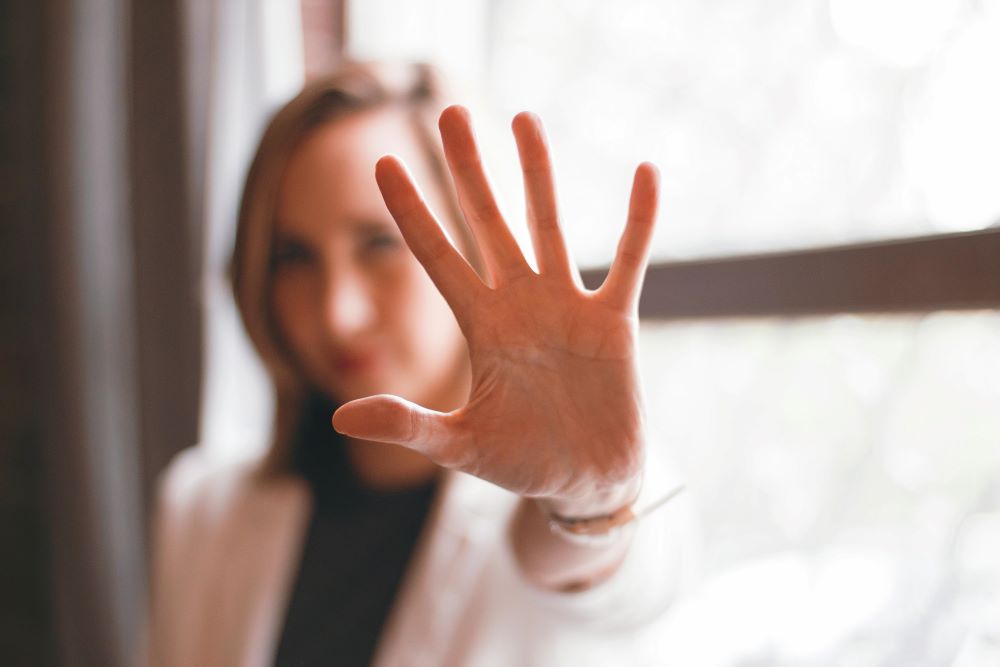 A woman holding her hand up to the camera